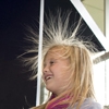Een kind experimenteert met statische elektriciteit in Technopolis. Haar haren worden omhoog geduwd.