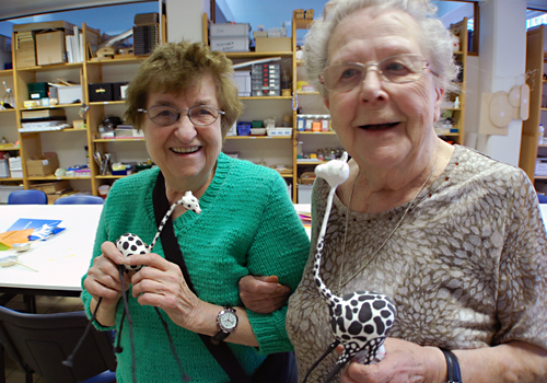 Twee senioren vermaken zich tijdens een BrailleClub.