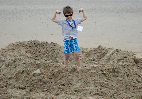 Un enfant déficient visuel joue sur la plage.