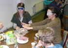 Des personnes mangent à table, les yeux bandés lors d'une session de sensibilisation.