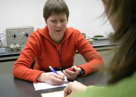 Jeune personne malvoyante en entretien avec une membre du personnel de la Ligue Braille.