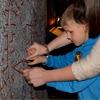 Een jongere met visuele handicap raakt een gravure in steen aan