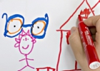 Un enfant dessine une maison et une paire de lunettes