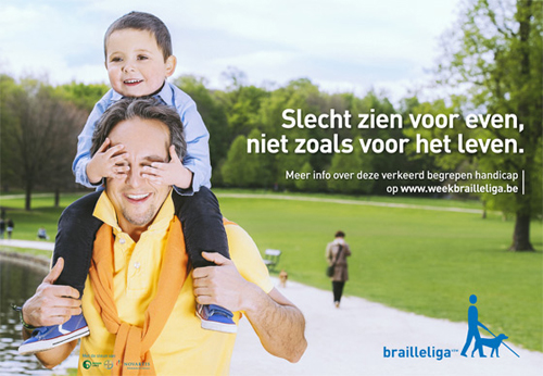 Een vader draagt zijn zoontje op de schouders tijdens een wandeling. De jongen bedekt de ogen van zijn papa met zijn handen en lacht.'