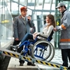 Une personne à mobilité réduite est accompagnée pour monter dans un train de la SNCB.