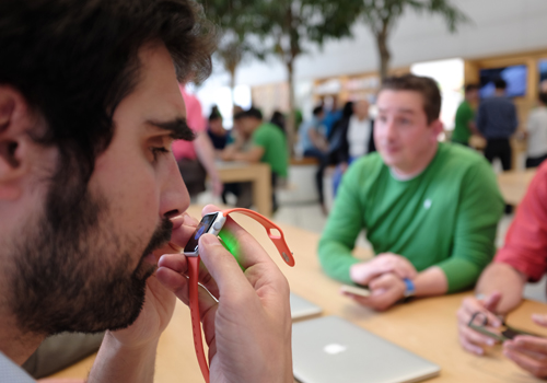 Une personne déficiente visuelle teste l’Apple Watch et la porte près de son regard.