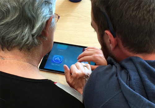 Deux personnes apprennent à utiliser la fonction Zoom d’un iPad.