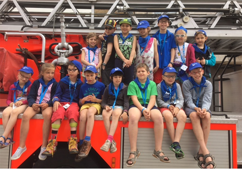 Photo de tous les enfants assis sur un camion de pompier.