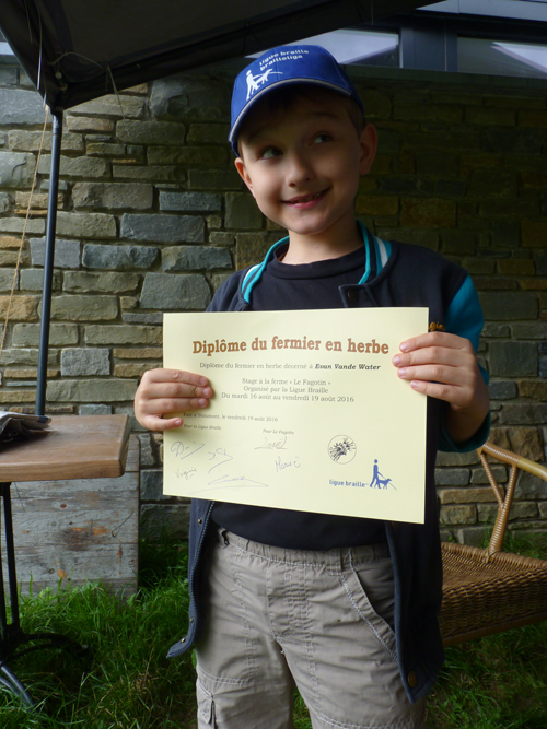 Un enfant reçoit son diplôme du fermier en herbe.