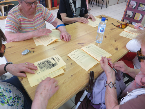 Chaque équipe de 5 à 6 enquêtrices est assise à une table, avec des carnets d'enquête pour noter les observations.