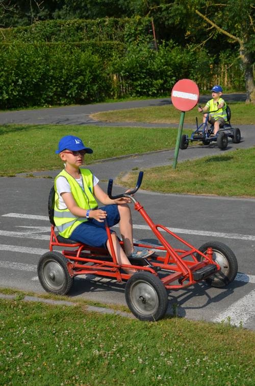 Twee jongens rijden elk met een gocart op een parcours.