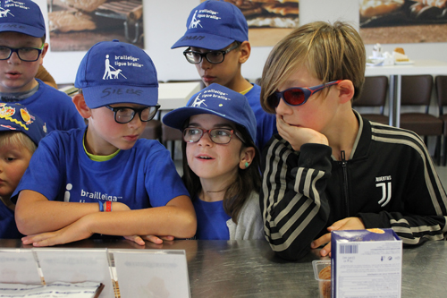 De kinderen wachten tot ze een koekje kunnen proeven. 