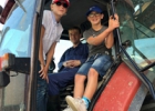 Twee kinderen en een boer in een tractor. 