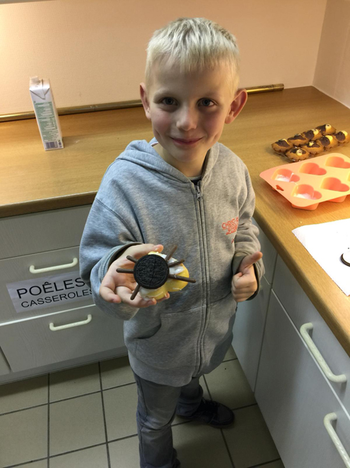 Un jeune enfant avec un cupcake décoré. 