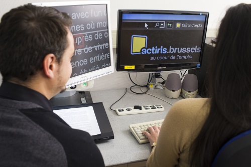 Un collaborateur de la Ligue Braille vérifie comment une femme avec une déficience visuelle visite le site web d’Actiris.  