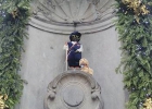 Manneken Pis habillé en Louis Braille, avec des lunettes noires, une canne blanche de locomotion et un chien-guide en peluche.