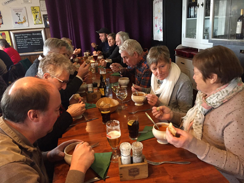 Tiental mensen aan het eten aan dezelfde tafel in een restaurant. 