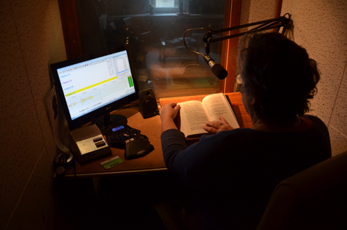 Een persoon leest een boek in in een studio.