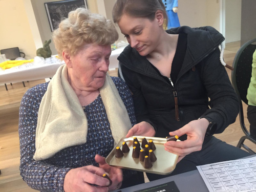 een jonge vrouw die chocolade aan een bejaarde dame geeft