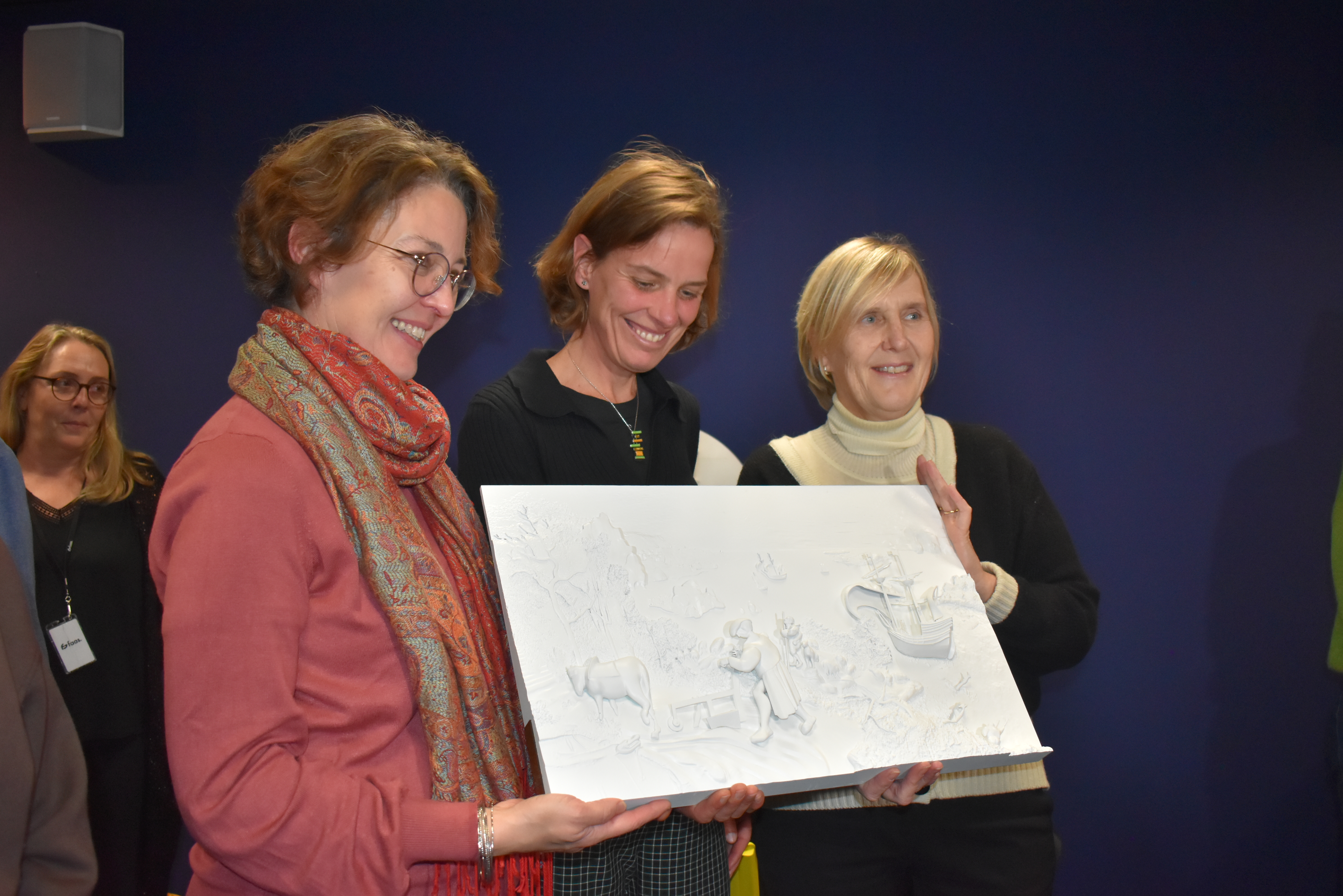 L'équipe des Musées royaux des Beaux-Arts de Belgique prend la pose avec la reproduction tactile offerte par la Ligue Braille