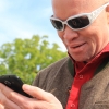Een blinde persoon zoekt iets op zijn smartphone.