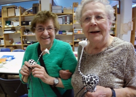 Two elderly people having fun at the Brussels Braille Club.