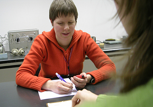 A young partially sighted person in conversation with a Ligue Braille member of staff.