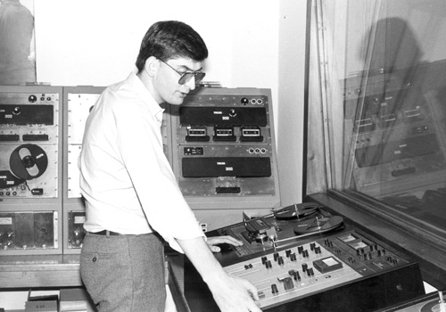 Archiefbeeld van een persoon voor een cassetterecorder geschikt voor studio-opnames